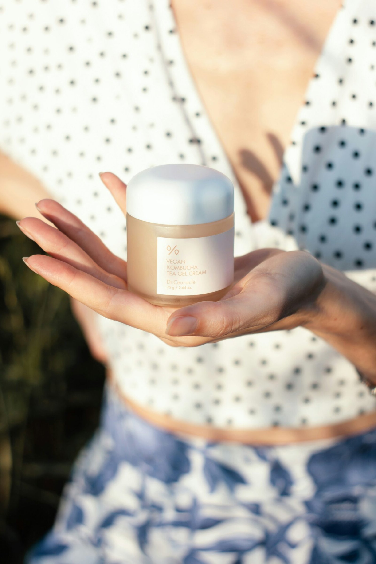 a woman holding a jar of cream in her hand